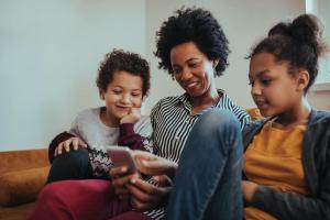 Mom sits on the couch with her two children