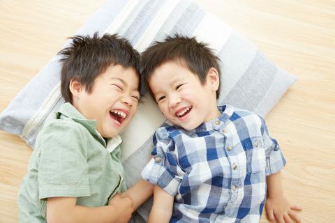 Brothers lying on pillow laughing