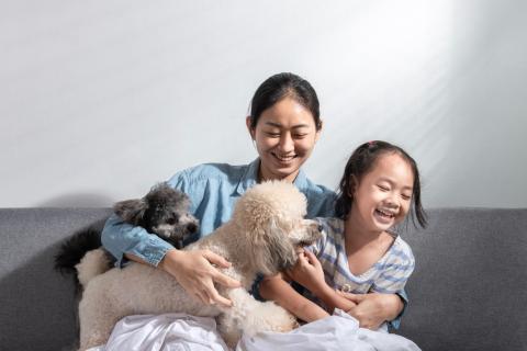 Mom and daughter with two dogs on the couch. 