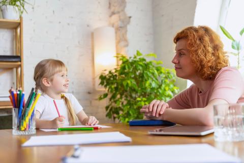 Little girl talking to counsellor in an office.