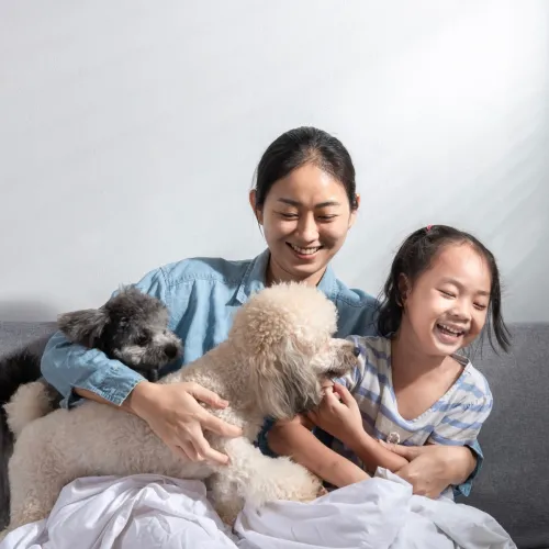 Mom and daughter with two dogs on the couch. 