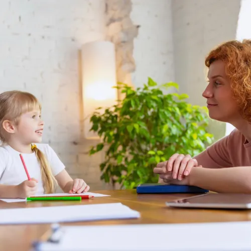 Little girl talking to counsellor in an office.