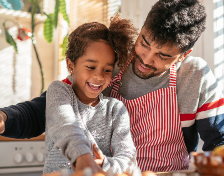 A father and daughter cook together in their home kitchen.