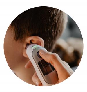 Child's temperature being taken by parent with an ear thermometer