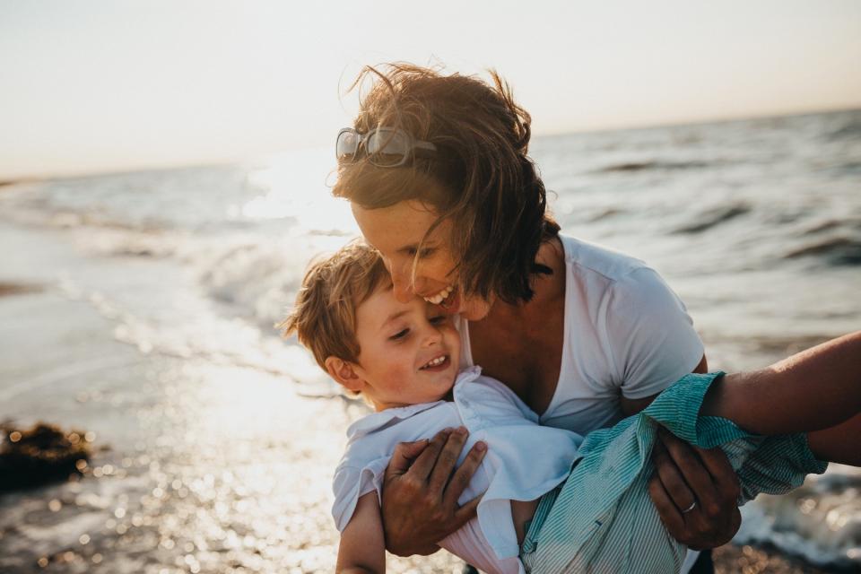 Mom and son play on the beach.