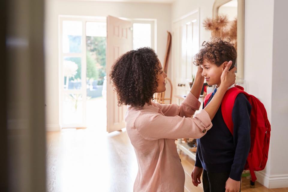 A mother sends her child off to school.