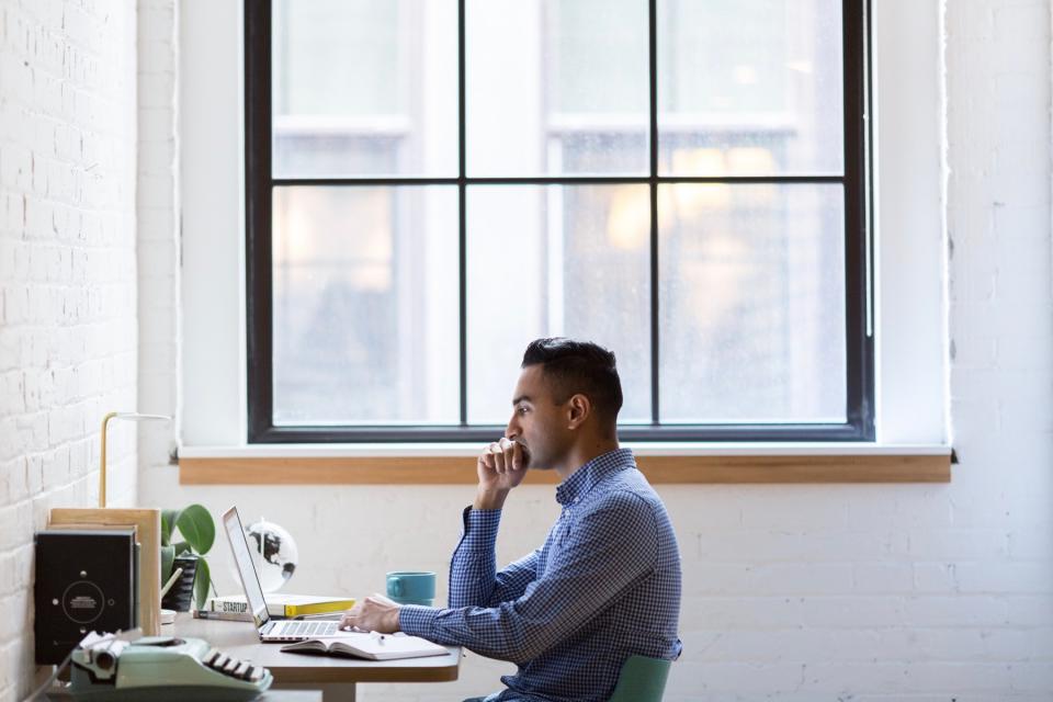 Man does research on his computer in an office.