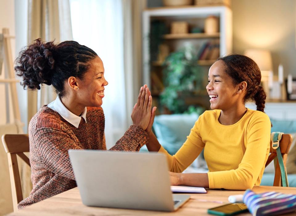 Woman helping young girl with her homework.