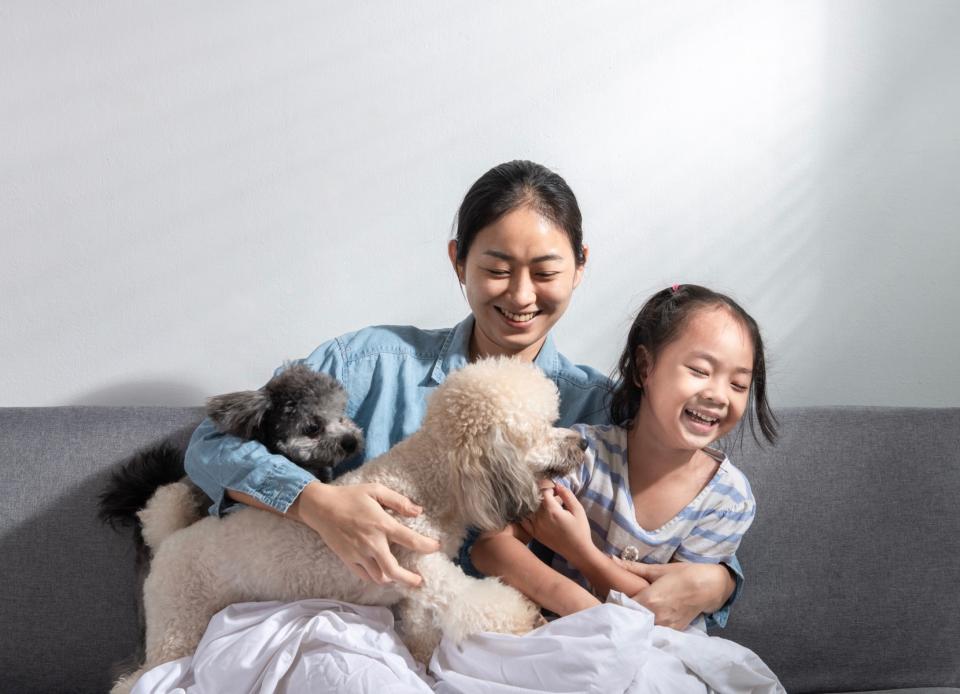 Mom and daughter with two dogs on the couch. 